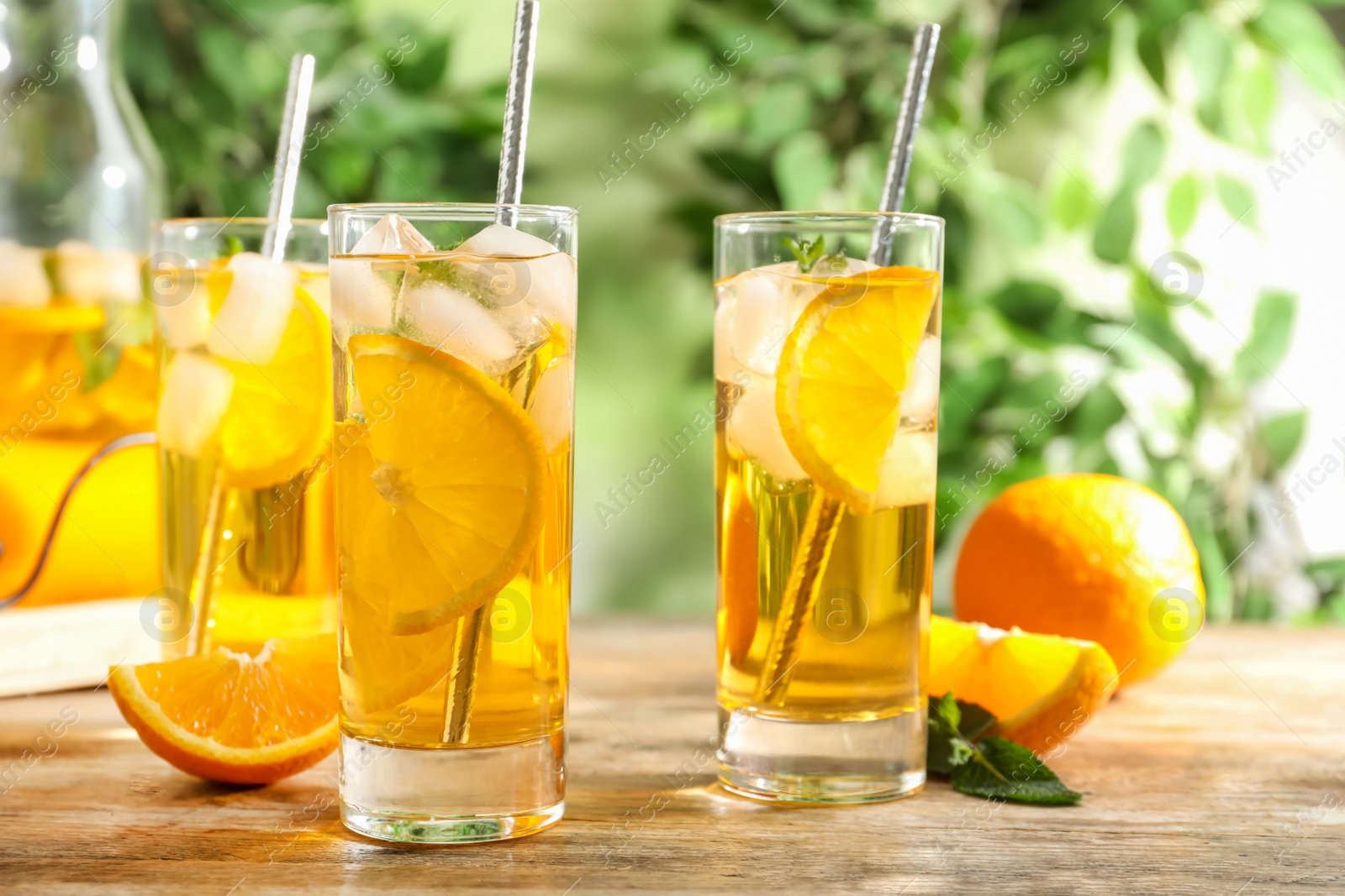 Photo of Delicious refreshing drink with orange slices on wooden table