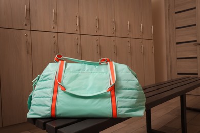 Photo of Sports bag on wooden bench in locker room