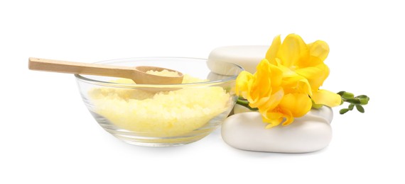 Photo of Yellow sea salt in bowl, flowers, spa stones and spoon isolated on white