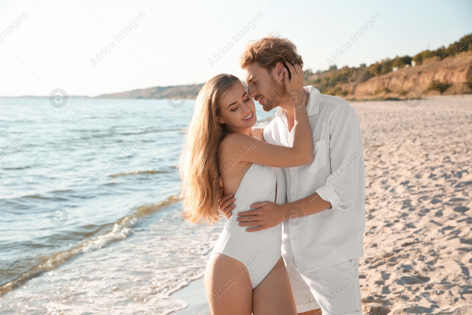 Photo of Romantic young couple spending time together on beach. Space for text