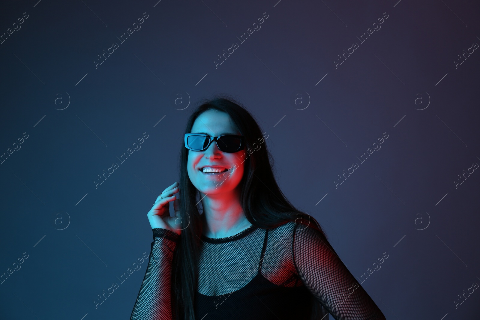 Photo of Portrait of beautiful young woman with sunglasses on color background