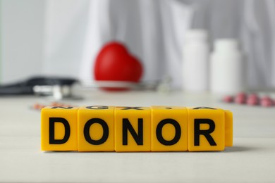 Word Donor made of cubes on white wooden table