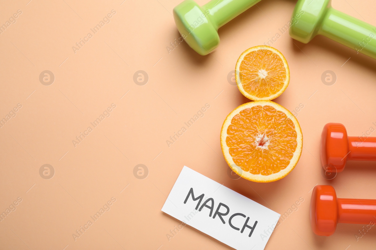 Photo of 8 March greeting card design with cut citrus, dumbbells and space for text on orange background, flat lay. International Women's day