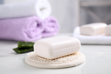 Soap bar and cloth on white table indoors