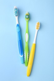 Many different toothbrushes on light blue background, flat lay