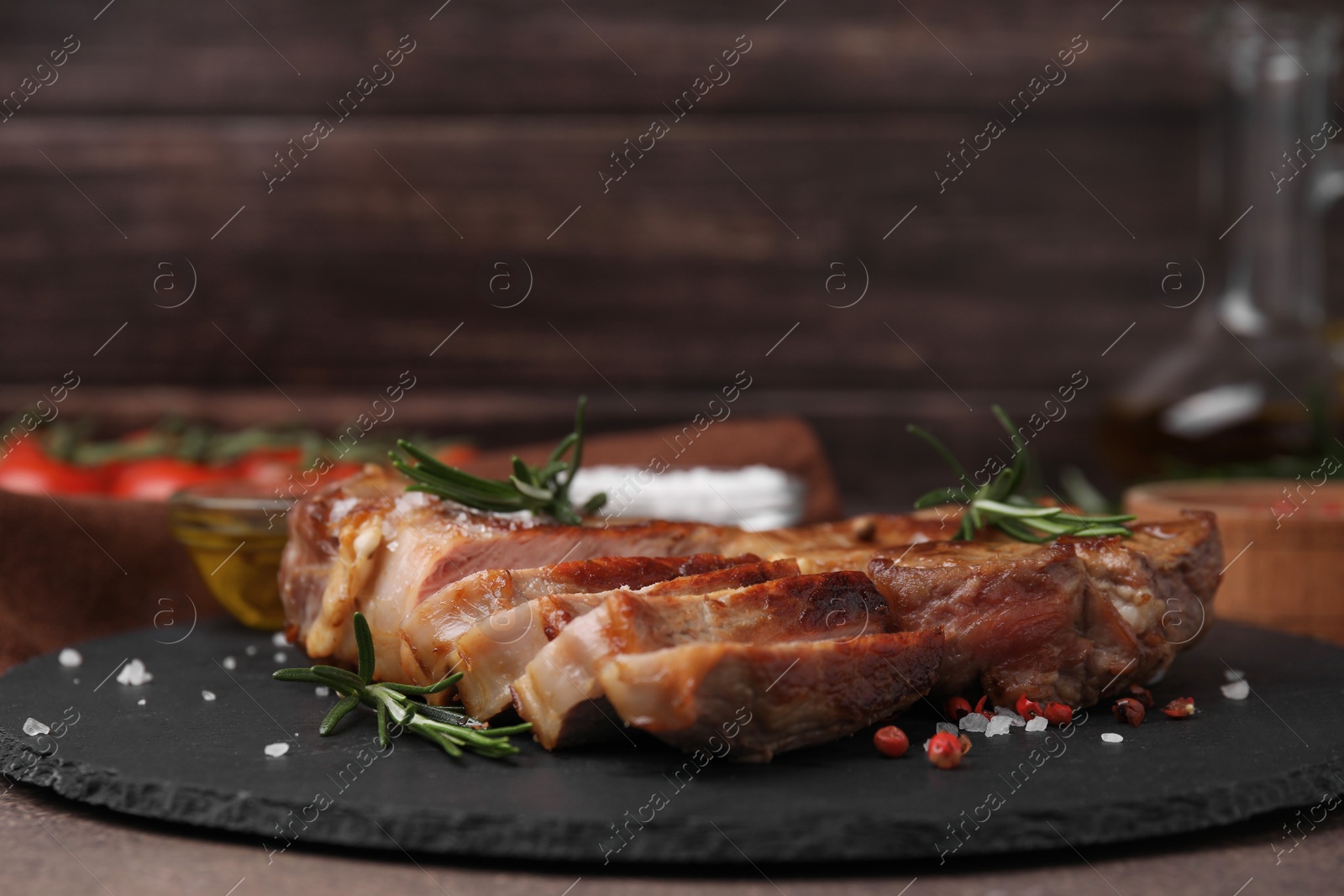 Photo of Pieces of delicious fried meat with rosemary and spices on table, closeup