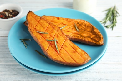 Plate with baked sweet potato on white wooden table, closeup