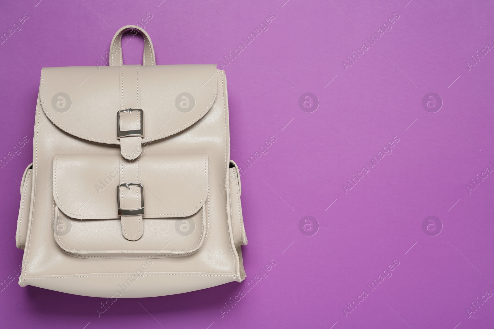 Photo of Stylish urban backpack on violet background, top view. Space for text