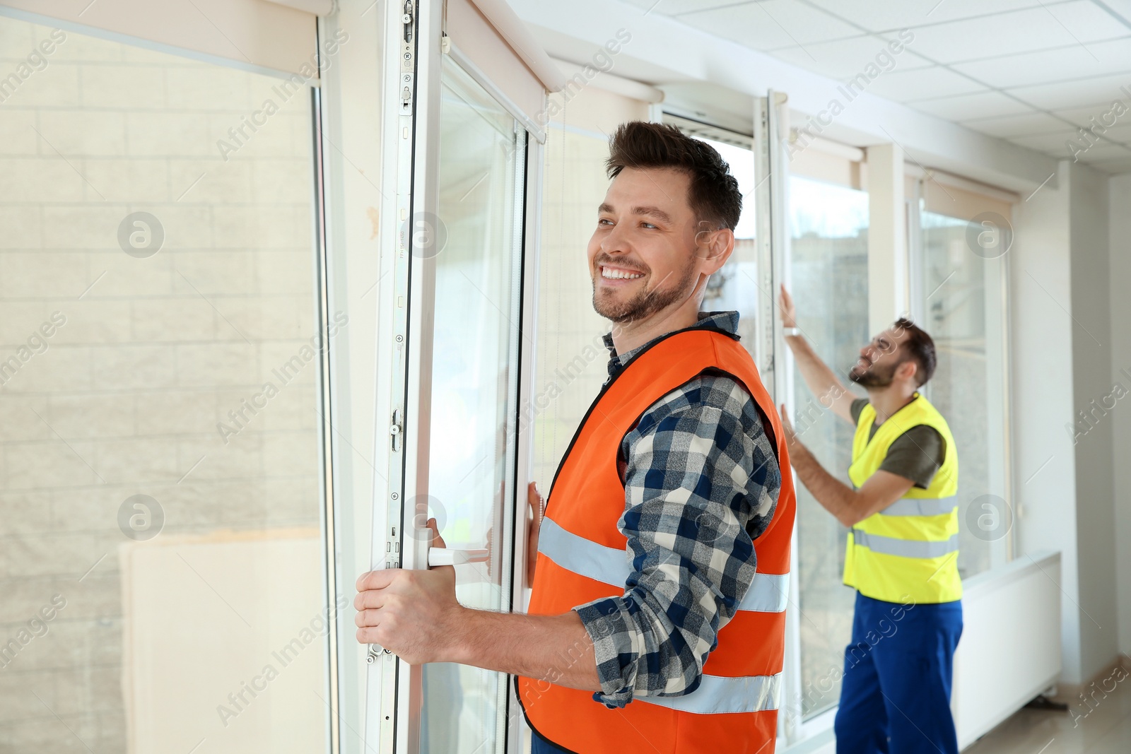 Photo of Construction workers installing plastic windows in house