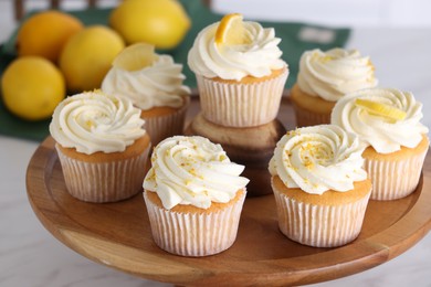 Photo of Delicious lemon cupcakes with white cream on table, closeup