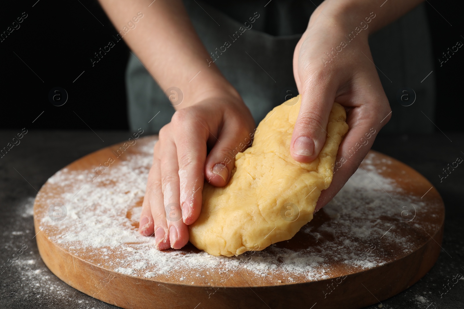 Photo of Making shortcrust pastry. Woman kneading dough at table, closeup