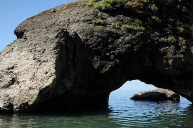 Picturesque view of natural stone arch above sea. Rock formation