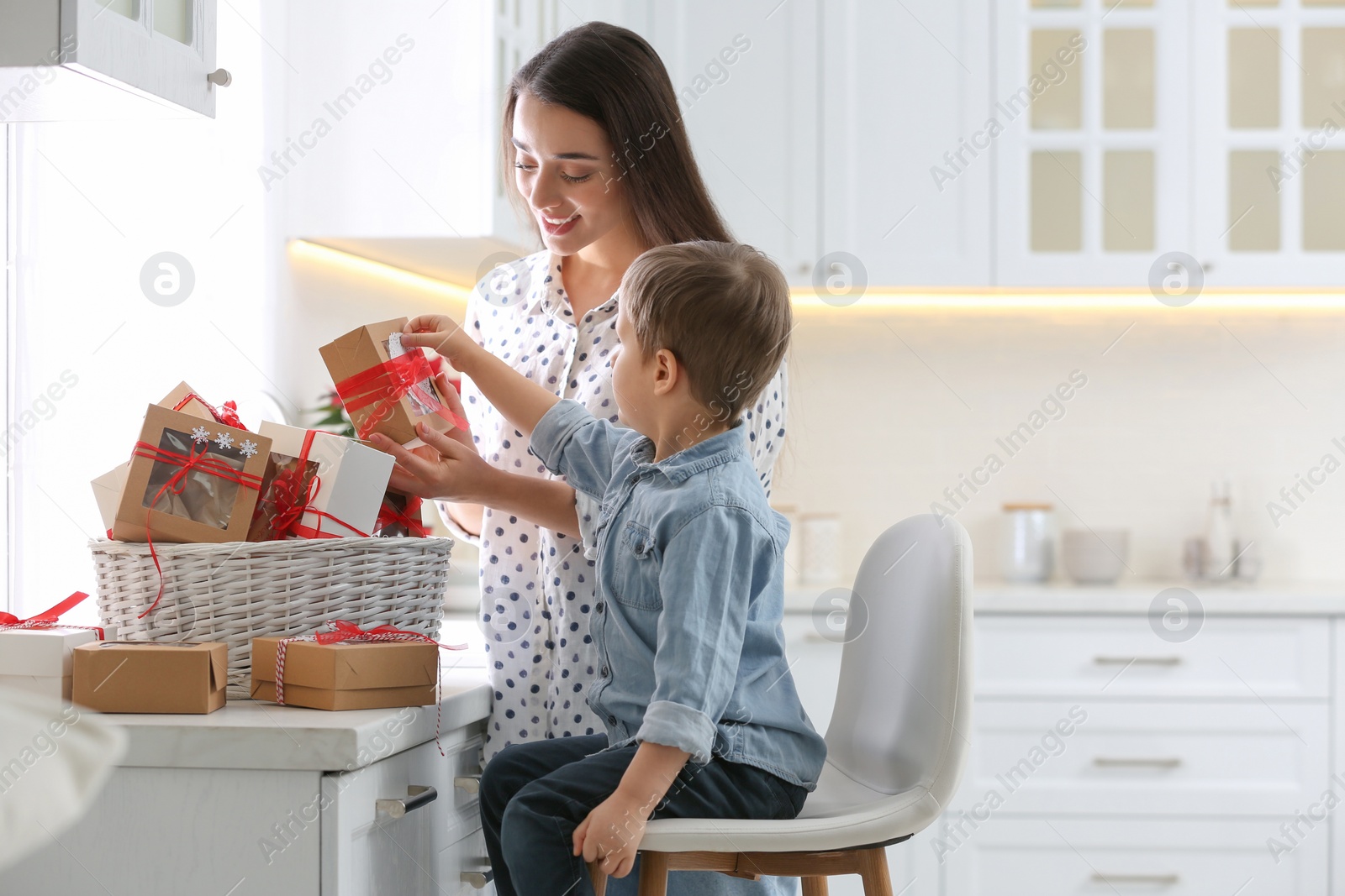 Photo of Mother and son with Christmas gifts at home. Advent calendar in basket