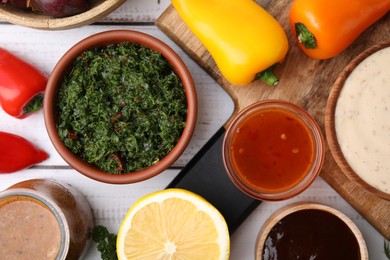 Photo of Different fresh marinades and ingredients on white wooden table, flat lay