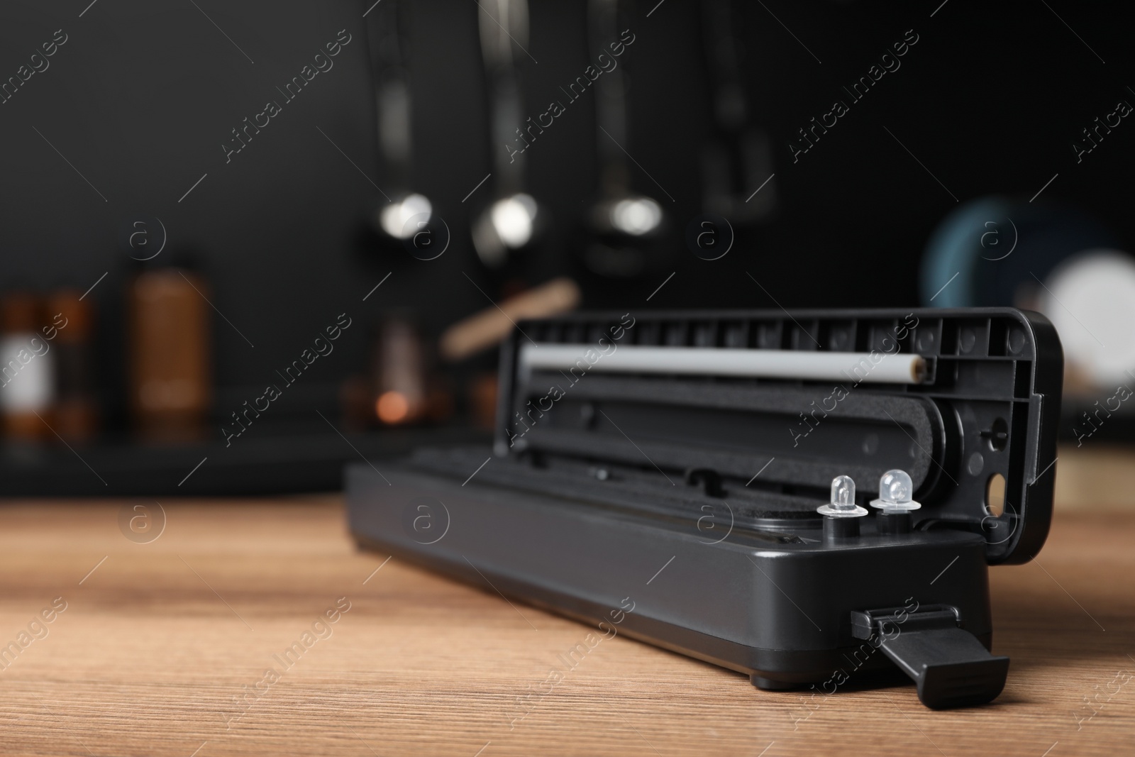 Photo of Sealer for vacuum packing on wooden table in kitchen