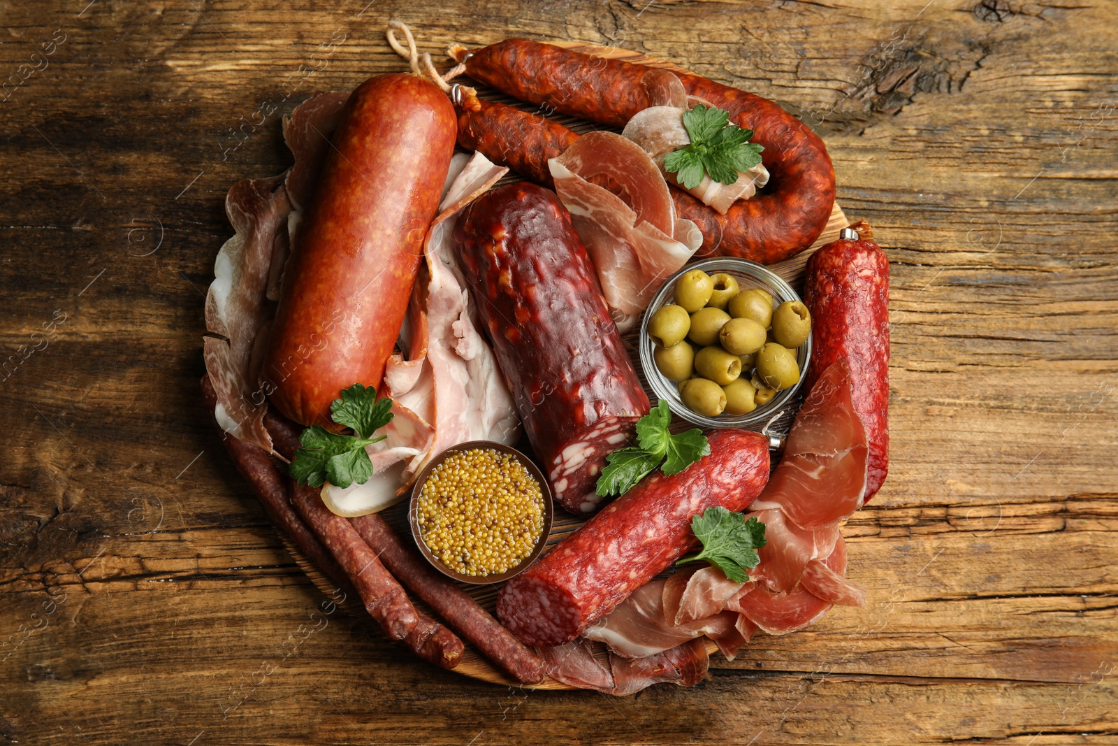 Photo of Different types of sausages served on wooden table, top view