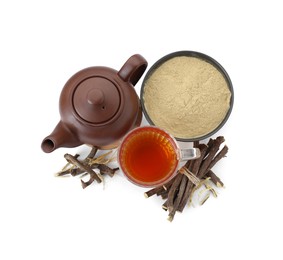 Photo of Aromatic licorice tea in cup, teapot, dried sticks of licorice root and powder isolated on white, top view