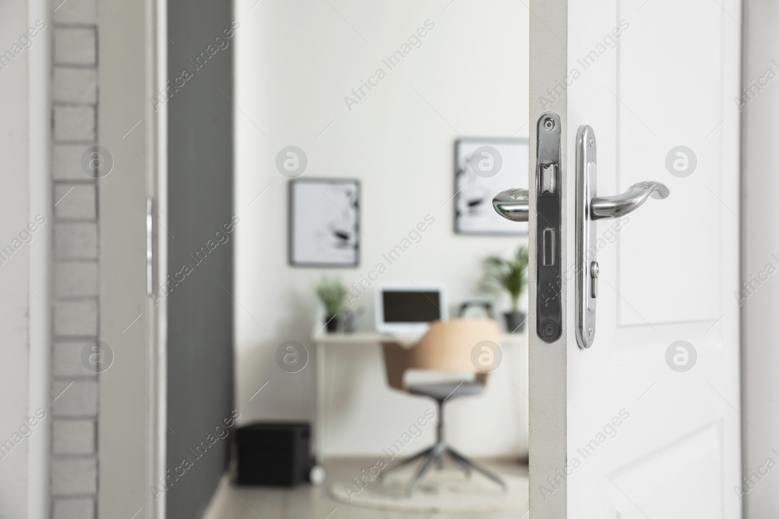 Photo of Stylish home office interior, view through open door