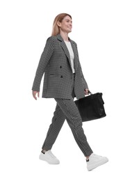 Beautiful happy businesswoman in suit with briefcase walking on white background