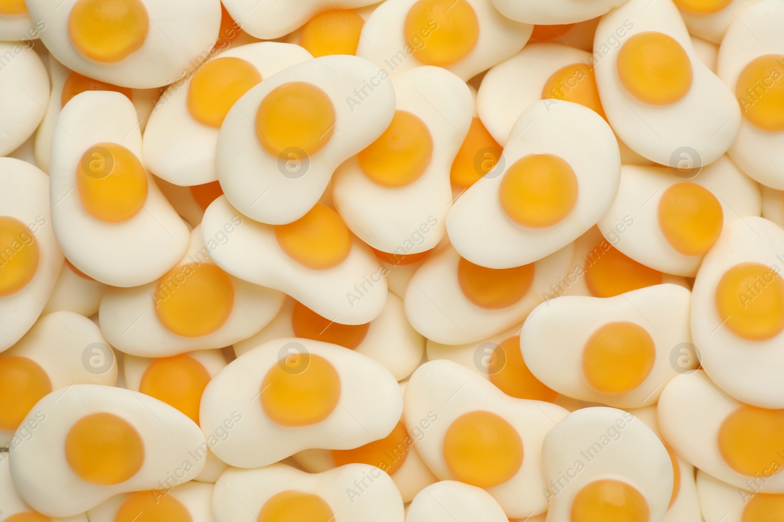 Photo of Tasty jelly candies in shape of egg as background, top view