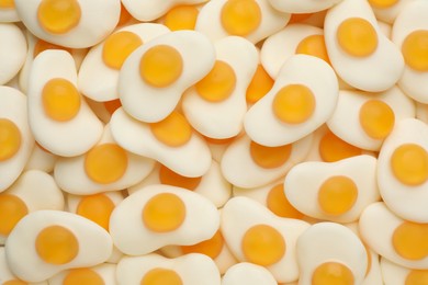 Tasty jelly candies in shape of egg as background, top view