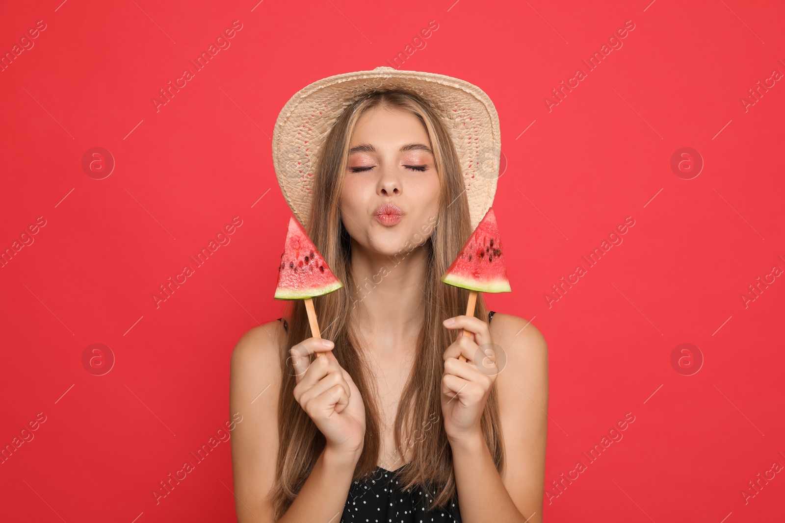 Photo of Beautiful girl with pieces of watermelon on red background