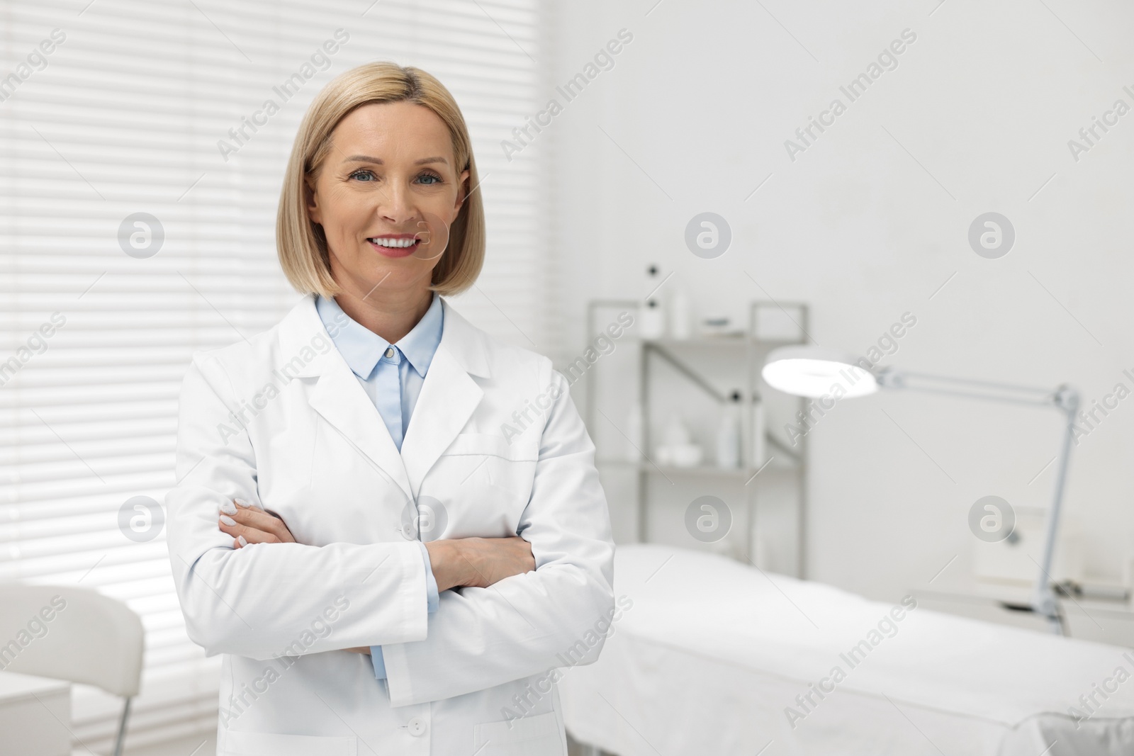 Photo of Portrait of happy dermatologist in modern clinic, space for text