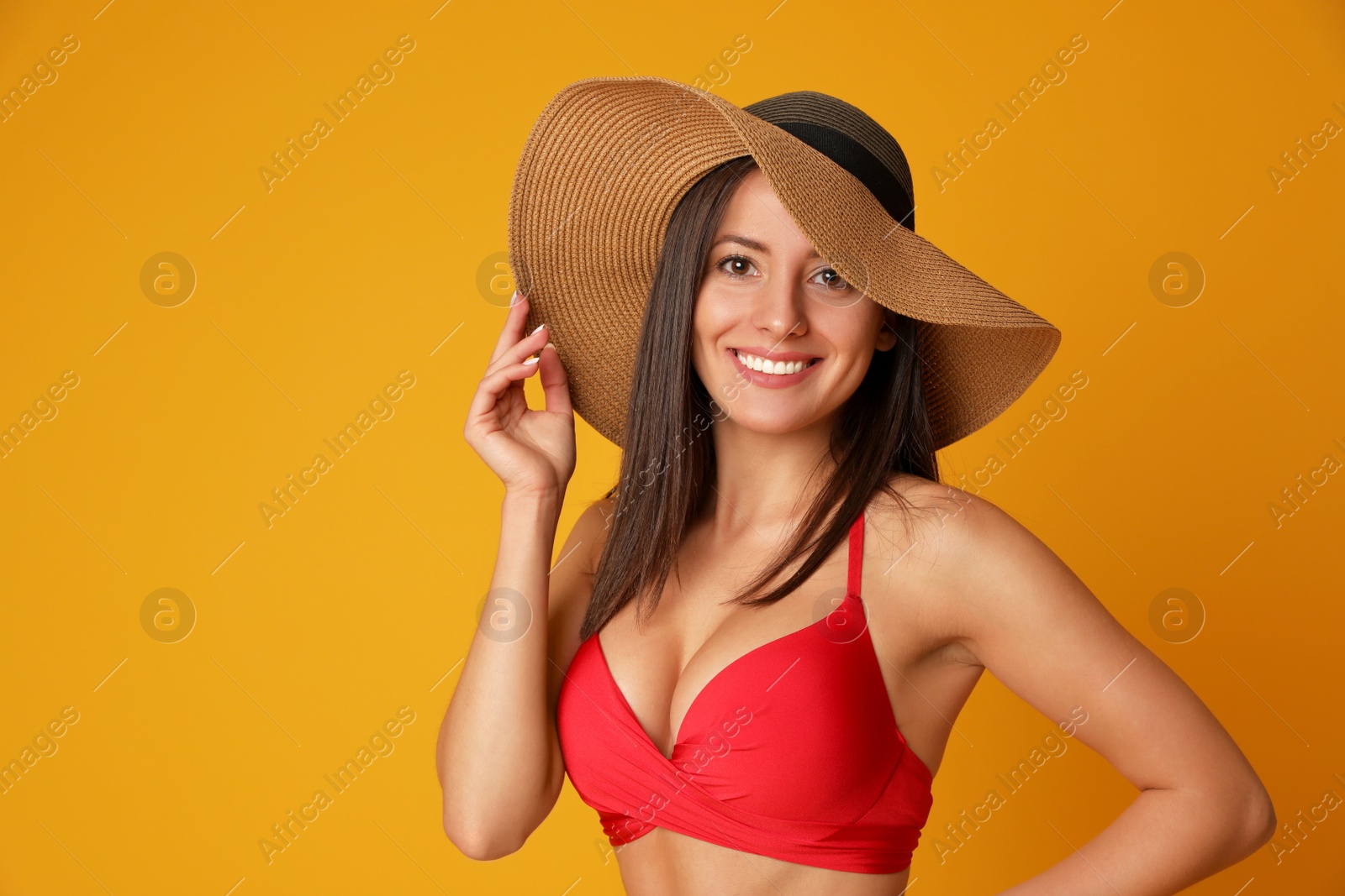 Photo of Pretty sexy woman with slim body in stylish red bikini on orange background, space for text