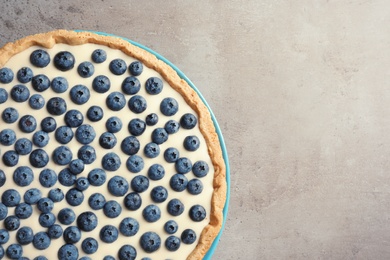 Tasty blueberry cake on gray background, top view with space for text