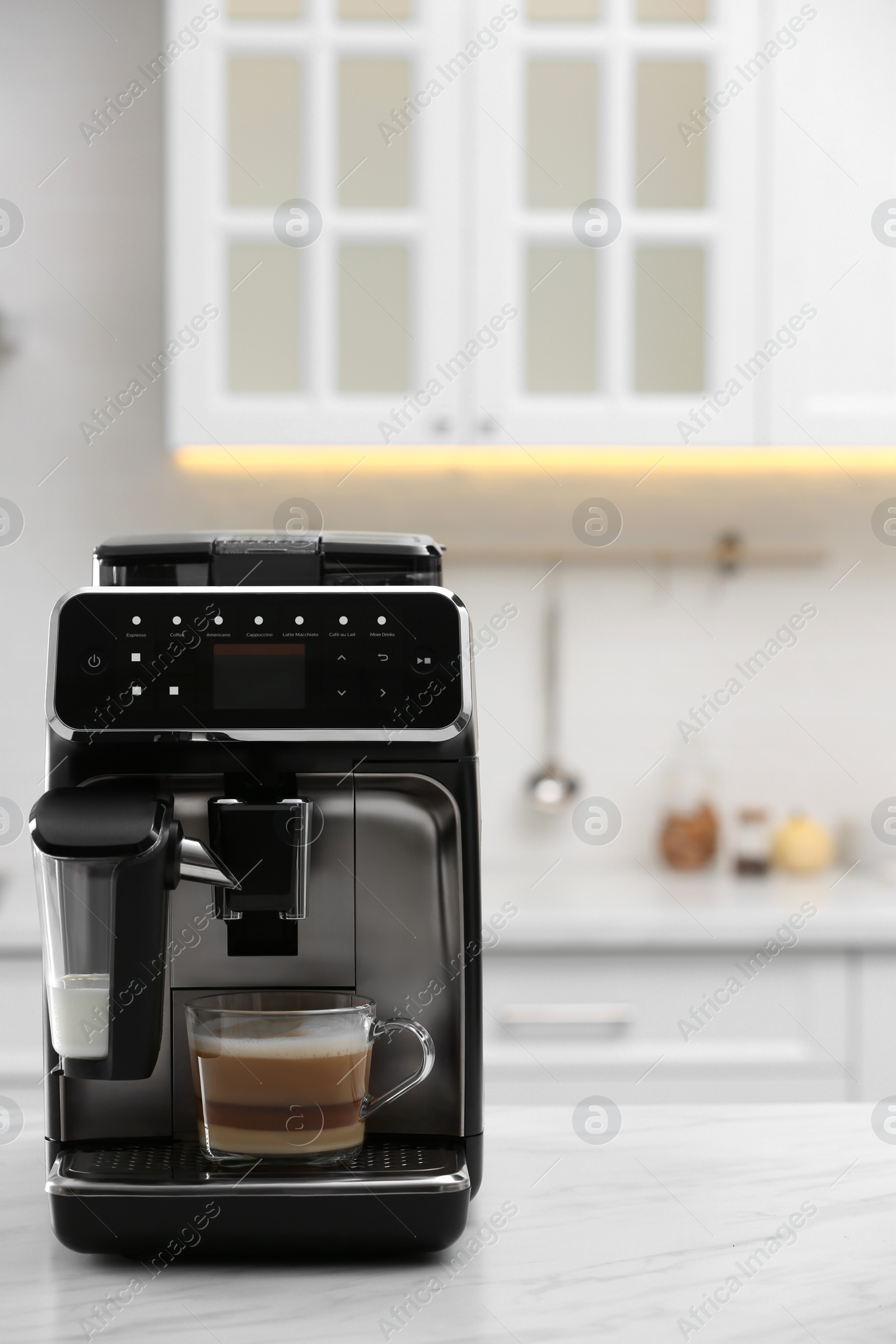 Photo of Modern coffee machine with glass cup of latte on white marble countertop in kitchen