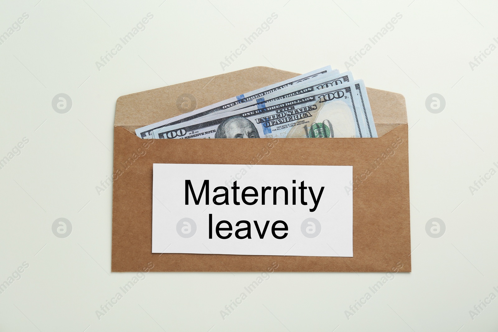 Photo of Maternity leave concept. Envelope with dollar banknotes and note on white background, top view
