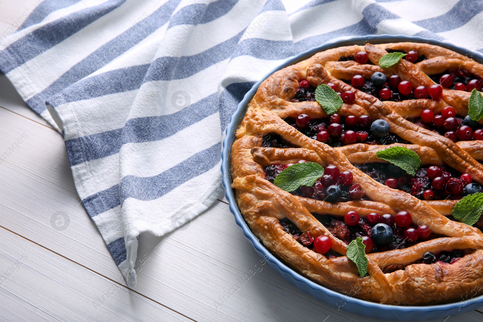 Photo of Delicious currant pie and fresh berries on white wooden table