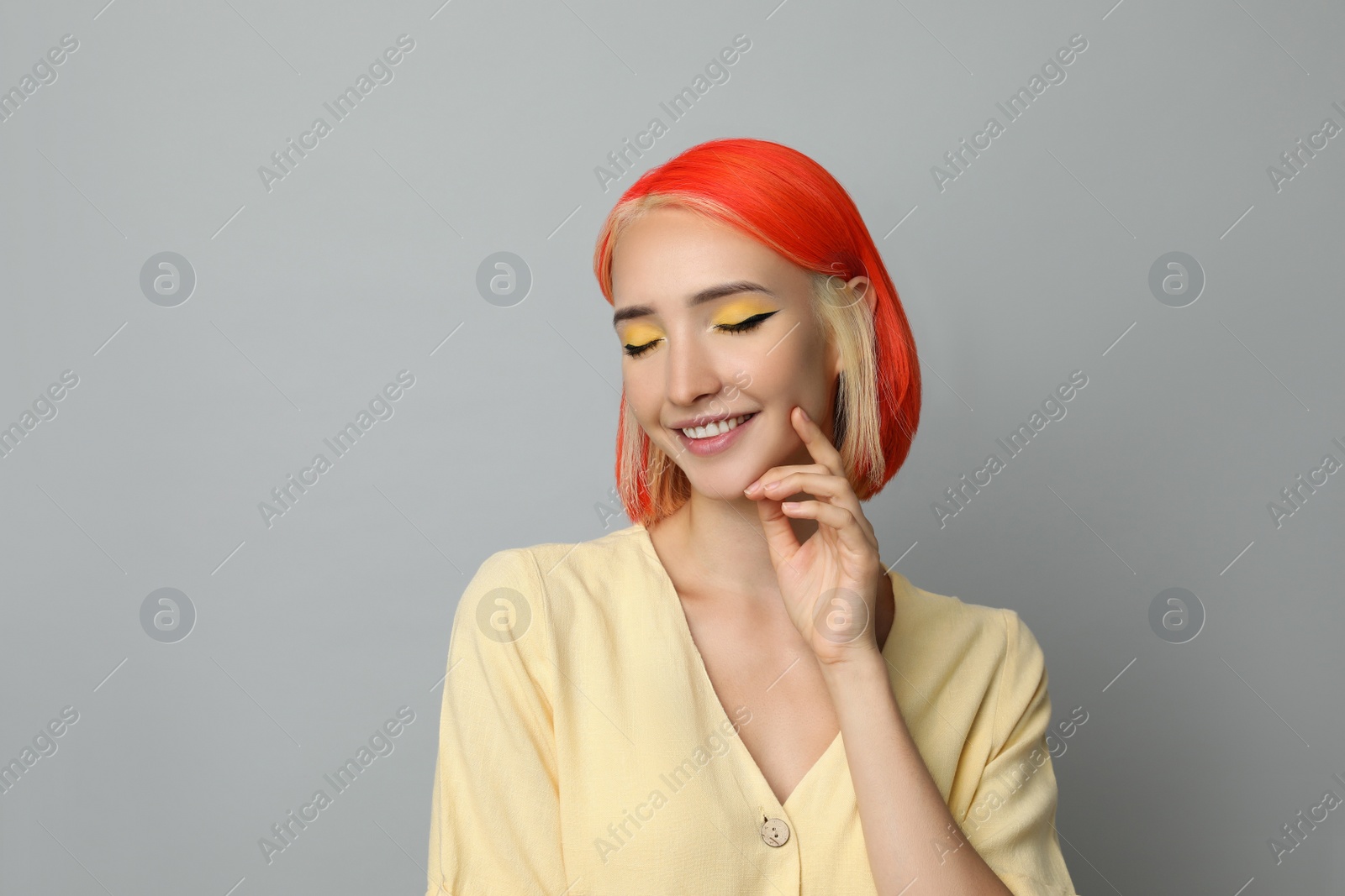 Photo of Beautiful young woman with bright dyed hair on light grey background