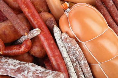 Different tasty sausages as background, top view