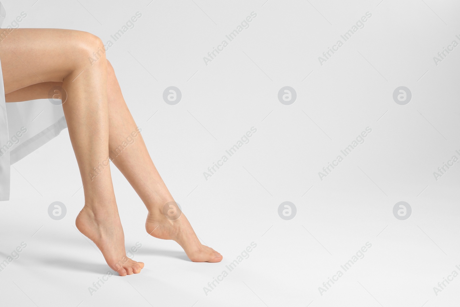 Photo of Woman with beautiful smooth legs on white background, closeup. Space for text