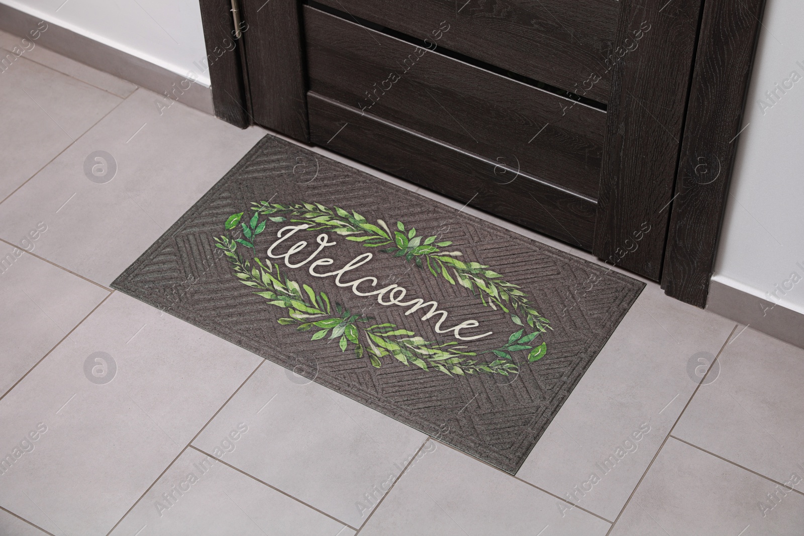 Photo of Beautiful doormat with word Welcome on floor near entrance