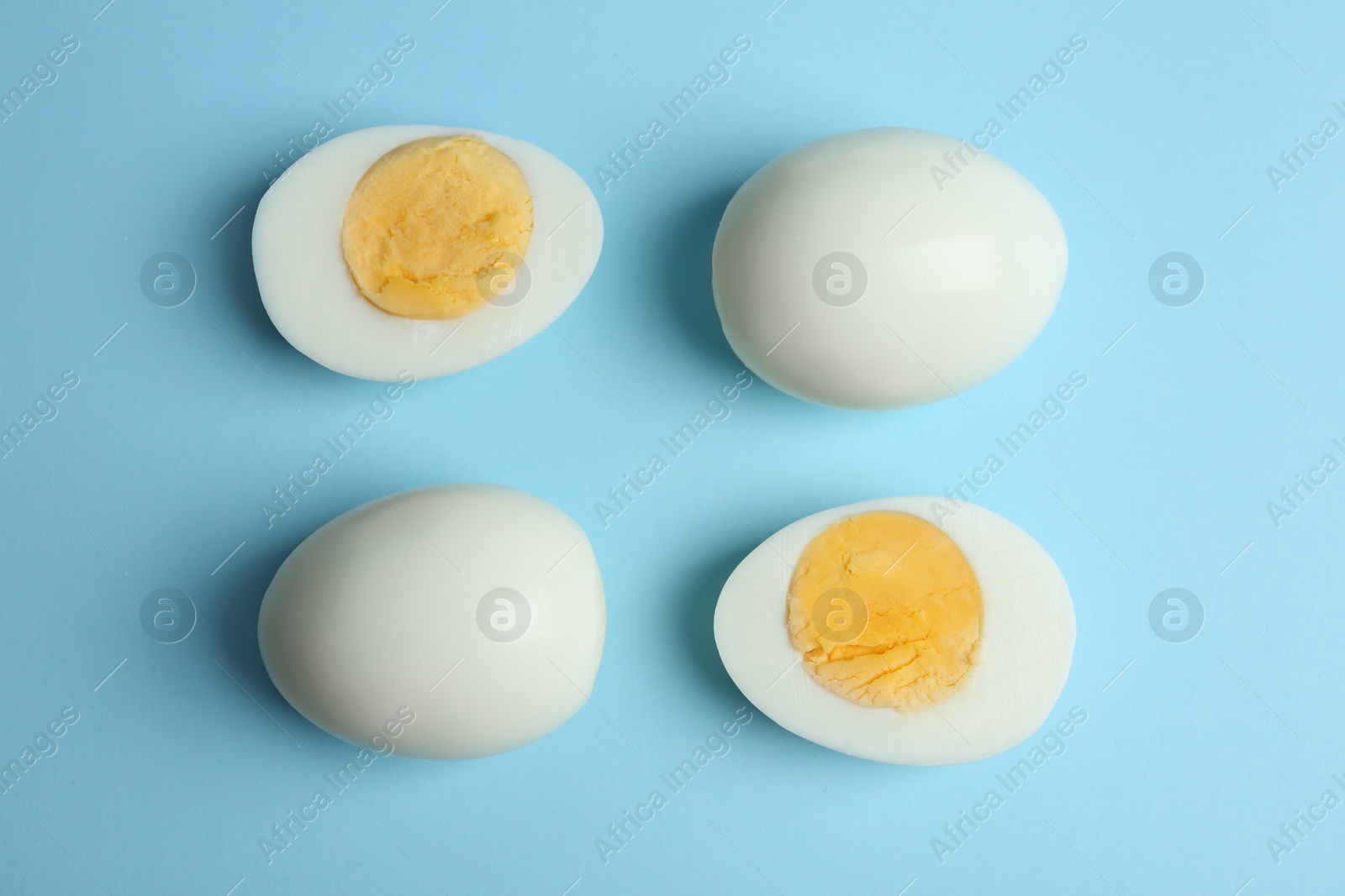 Photo of Fresh hard boiled chicken eggs on light blue background, flat lay