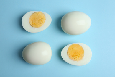 Photo of Fresh hard boiled chicken eggs on light blue background, flat lay