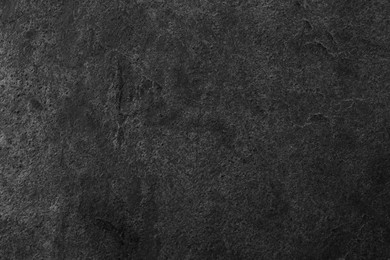 Texture of dark grey stone surface as background, closeup