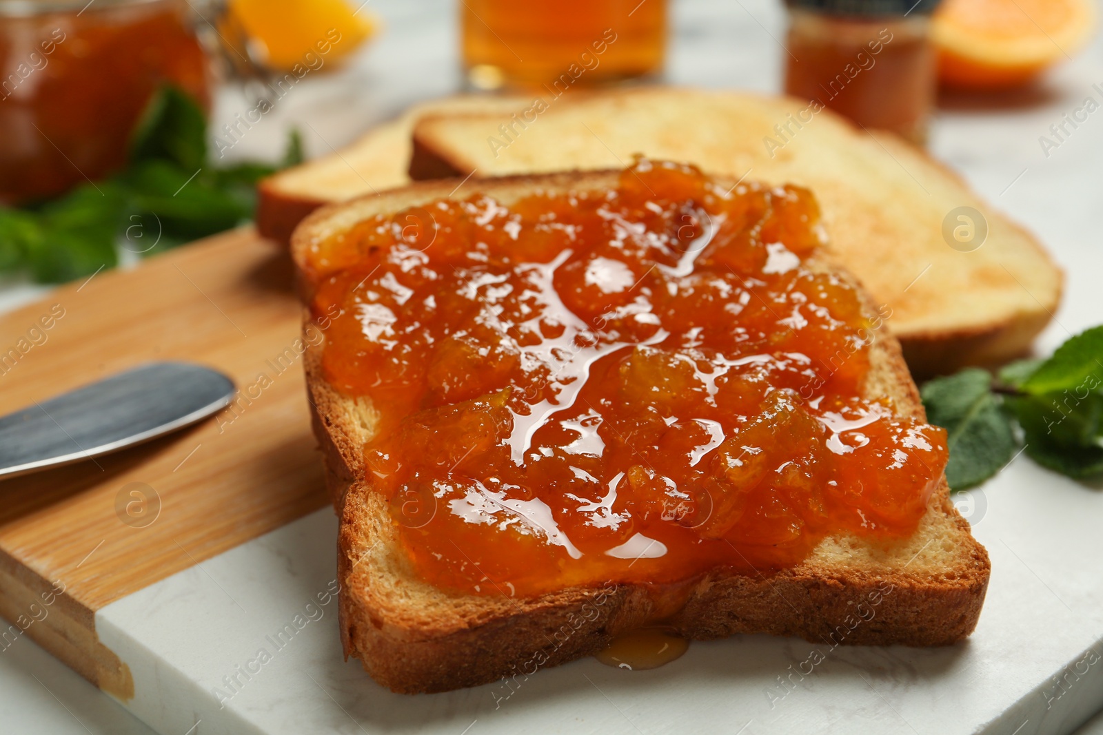 Photo of Delicious toasts with jam on board, closeup