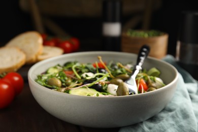 Photo of Fresh salad with vegetables, capers and mozzarella in bowl, closeup