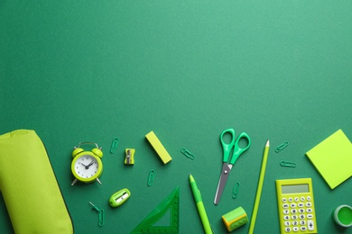 Photo of Bright school stationery on green background, flat lay. Space for text