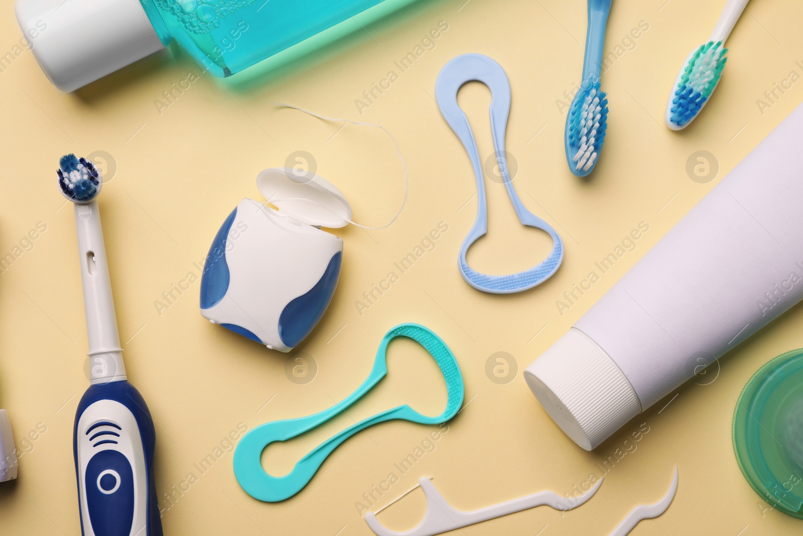 Photo of Flat lay composition with tongue cleaners and teeth care products on color background