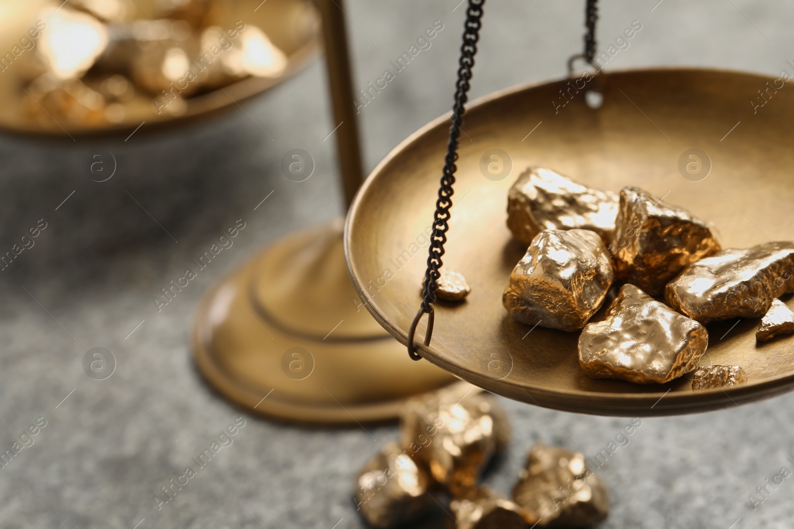 Photo of Vintage scales with gold nuggets on grey table, closeup. Space for text