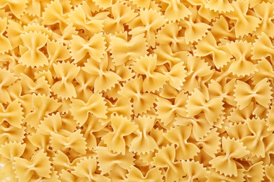 Uncooked farfalle pasta as background, closeup