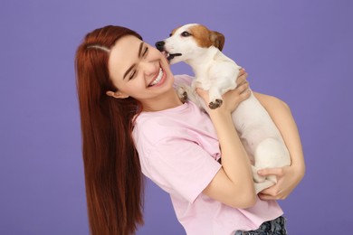 Photo of Happy woman with cute Jack Russell Terrier dog on violet background
