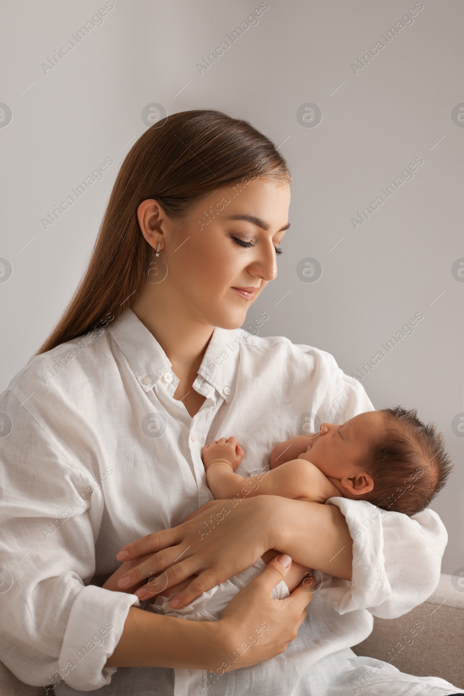 Photo of Mother holding her cute newborn baby indoors