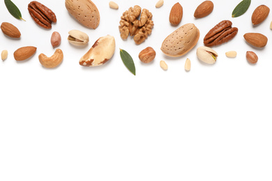 Different nuts and leaves on white background, flat lay. Space for text