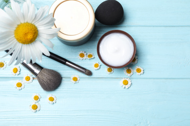 Photo of Flat lay composition with chamomile flowers and cosmetic products on wooden table