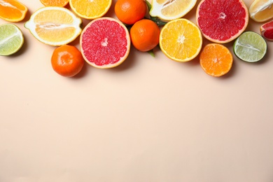 Different citrus fruits on color background, top view. Space for text